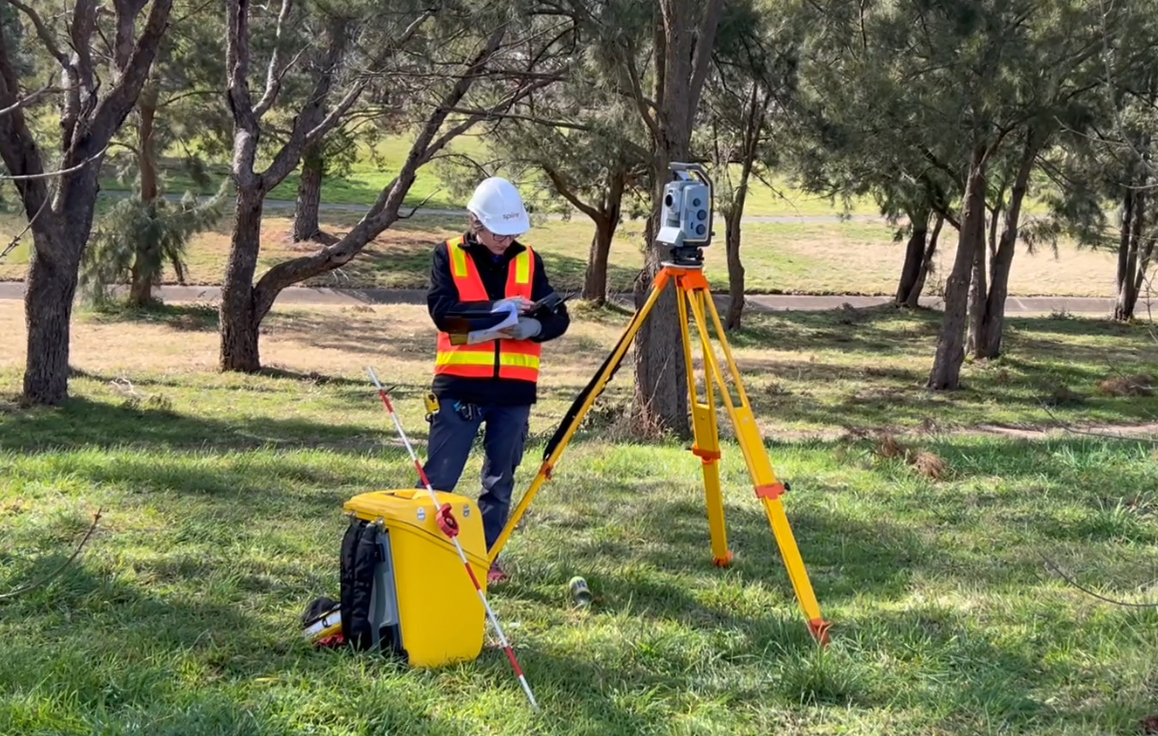 Spiire surveyor using survey equipment on site.